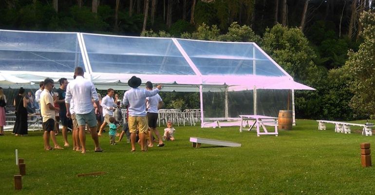 Guests playing lawn games beside the marquee